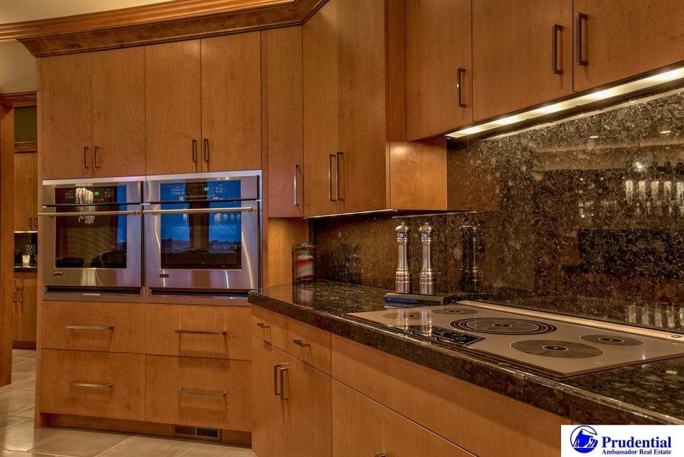 Foto på ett mycket stort funkis linjärt kök och matrum, med en undermonterad diskho, släta luckor, skåp i ljust trä, granitbänkskiva, svart stänkskydd, stänkskydd i sten, rostfria vitvaror, klinkergolv i porslin och en köksö