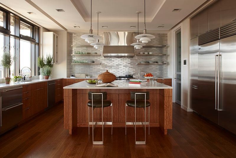 Ejemplo de cocina contemporánea abierta con puertas de armario de madera en tonos medios, electrodomésticos de acero inoxidable, suelo de madera oscura y dos o más islas