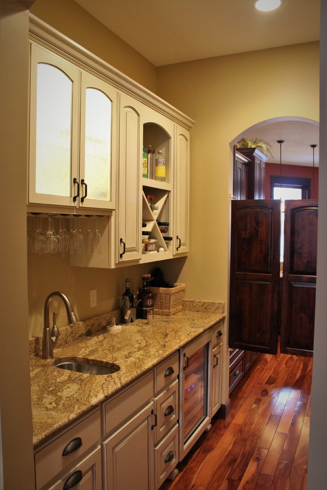 Example of a small trendy galley dark wood floor kitchen pantry design in Minneapolis with a drop-in sink, raised-panel cabinets, white cabinets, granite countertops, white appliances and no island