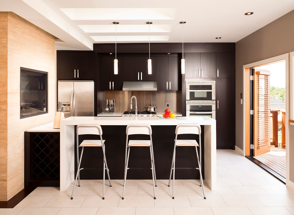 バンクーバーにあるコンテンポラリースタイルのおしゃれなキッチン (シルバーの調理設備、ステンレスのキッチンパネル) の写真