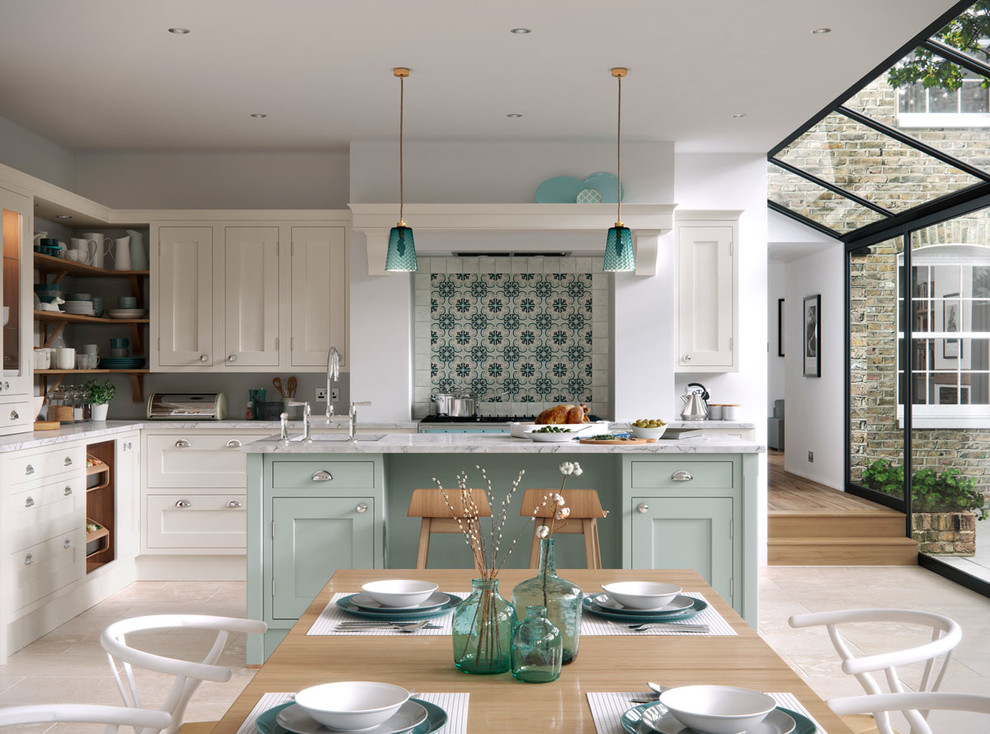 Cette photo montre une grande cuisine ouverte bicolore nature en L avec un placard à porte shaker, plan de travail en marbre, îlot, des portes de placard bleues et parquet clair.