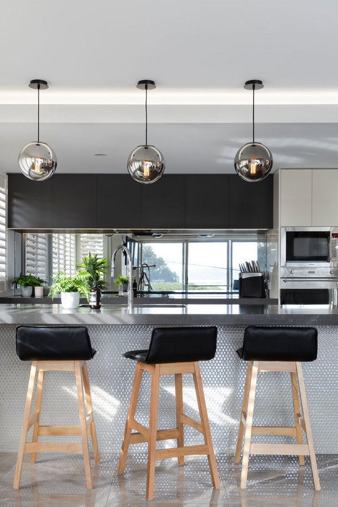 Inspiration för moderna grått kök, med släta luckor, fönster som stänkskydd, rostfria vitvaror och grått golv