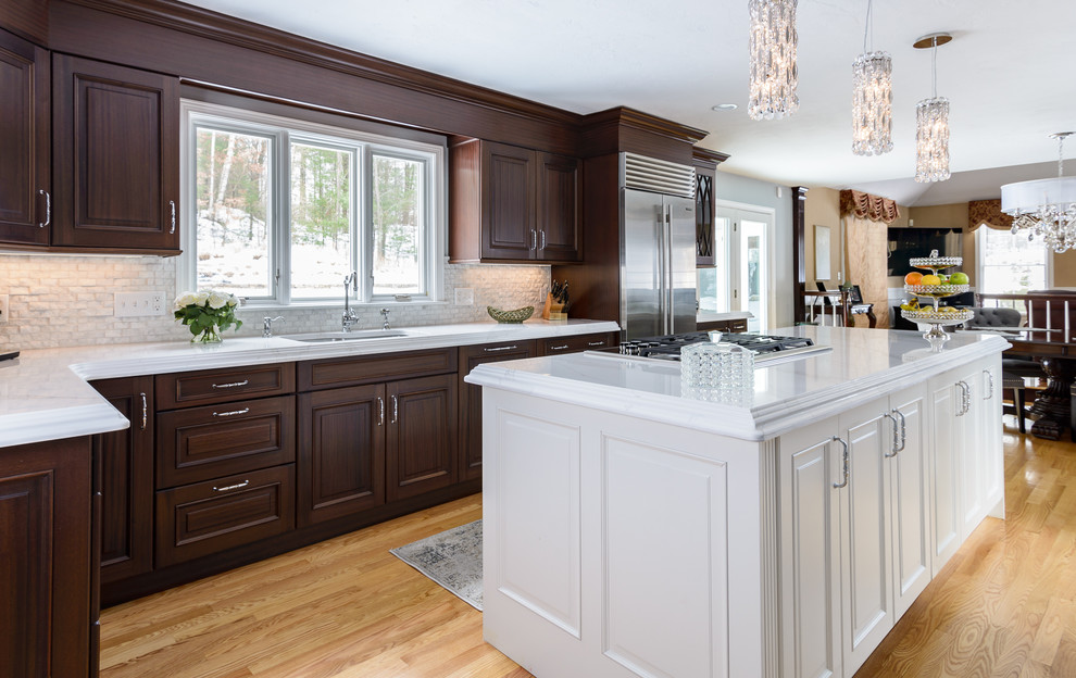 Inspiration for a large timeless l-shaped light wood floor and brown floor eat-in kitchen remodel in Boston with an undermount sink, raised-panel cabinets, dark wood cabinets, quartzite countertops, white backsplash, stone slab backsplash, stainless steel appliances and an island