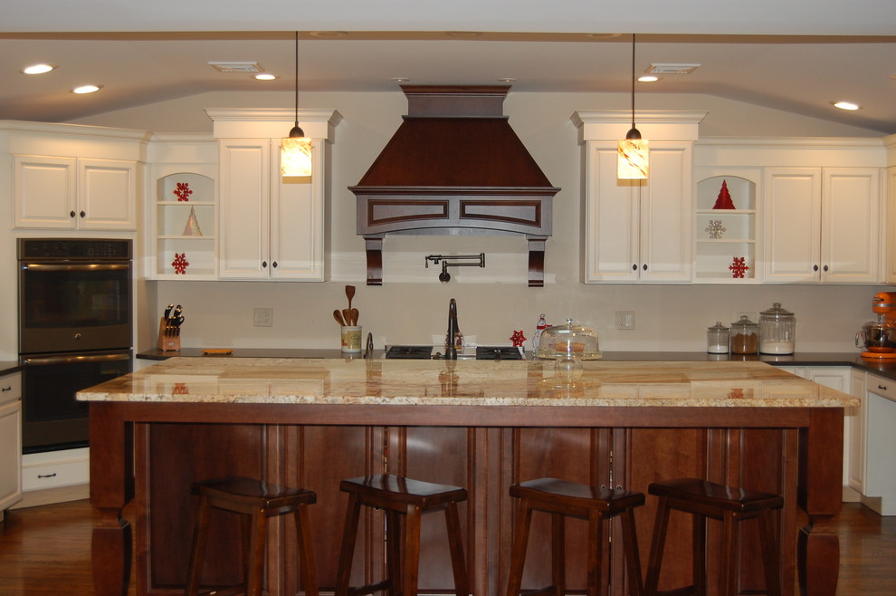 Пример оригинального дизайна: п-образная кухня-гостиная в современном стиле с белыми фасадами, гранитной столешницей, черной техникой, темным паркетным полом и островом