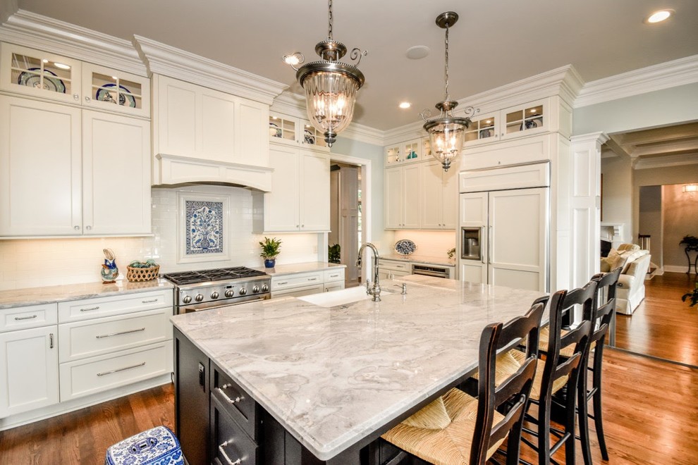 Example of a large cottage single-wall open concept kitchen design in Charlotte with a farmhouse sink, shaker cabinets, white cabinets, granite countertops, white backsplash, subway tile backsplash, stainless steel appliances and an island