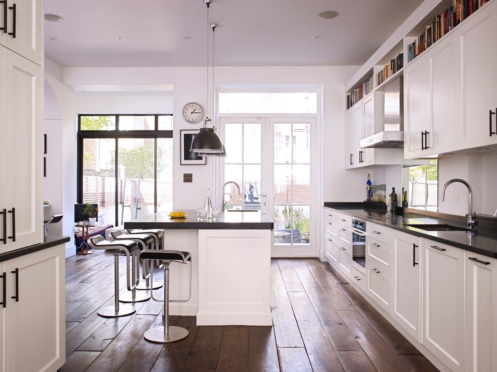 Große Moderne Wohnküche mit Schrankfronten im Shaker-Stil, schwarzen Elektrogeräten und Kücheninsel in London