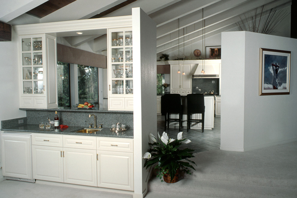 Bild på ett mellanstort vintage kök, med en undermonterad diskho, luckor med upphöjd panel, vita skåp, laminatbänkskiva, grått stänkskydd, stänkskydd i sten, rostfria vitvaror, heltäckningsmatta, en köksö och vitt golv