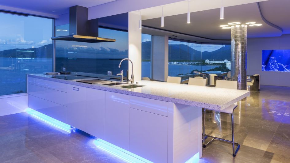 Photo of an expansive contemporary single-wall open plan kitchen in Cairns with white cabinets and an island.