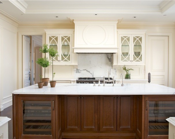 Bild på ett stort vintage kök, med en undermonterad diskho, vita skåp, marmorbänkskiva, vitt stänkskydd, stänkskydd i sten, luckor med infälld panel, rostfria vitvaror, mörkt trägolv och en köksö