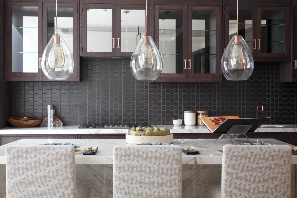 Mid-sized transitional single-wall kitchen photo in London with flat-panel cabinets, dark wood cabinets, marble countertops, black backsplash and an island