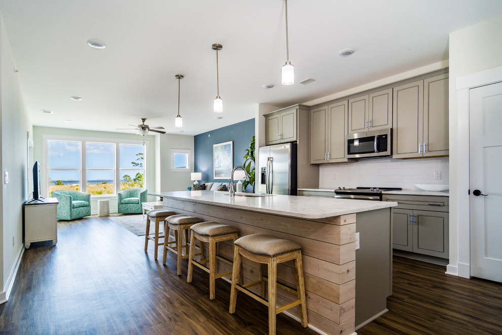 Inspiration for a coastal dark wood floor and brown floor kitchen remodel in Other with an undermount sink, shaker cabinets, gray cabinets, white backsplash, stainless steel appliances, an island and white countertops
