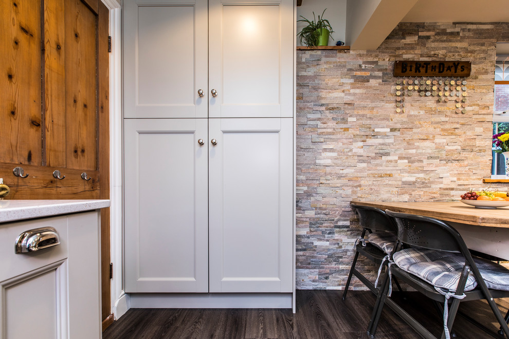 Eat-in kitchen - mid-sized modern l-shaped vinyl floor and brown floor eat-in kitchen idea in Hampshire with an undermount sink, shaker cabinets, gray cabinets, quartzite countertops, orange backsplash, glass sheet backsplash, white appliances and gray countertops