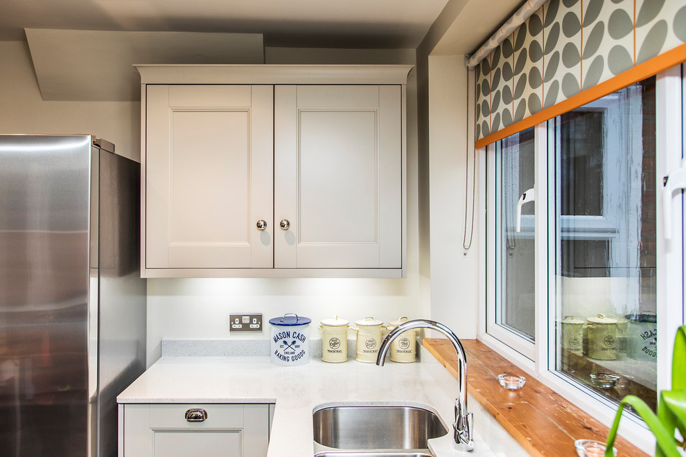 Esempio di una cucina minimalista di medie dimensioni con lavello sottopiano, ante in stile shaker, ante grigie, top in quarzite, paraspruzzi arancione, paraspruzzi con lastra di vetro, elettrodomestici bianchi, pavimento in vinile, pavimento marrone e top grigio