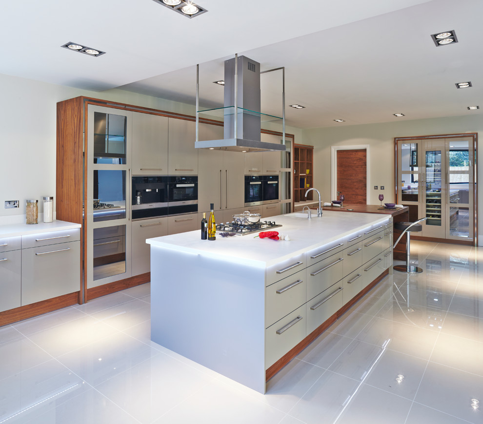 На фото: параллельная кухня-гостиная в современном стиле с плоскими фасадами, серыми фасадами и островом