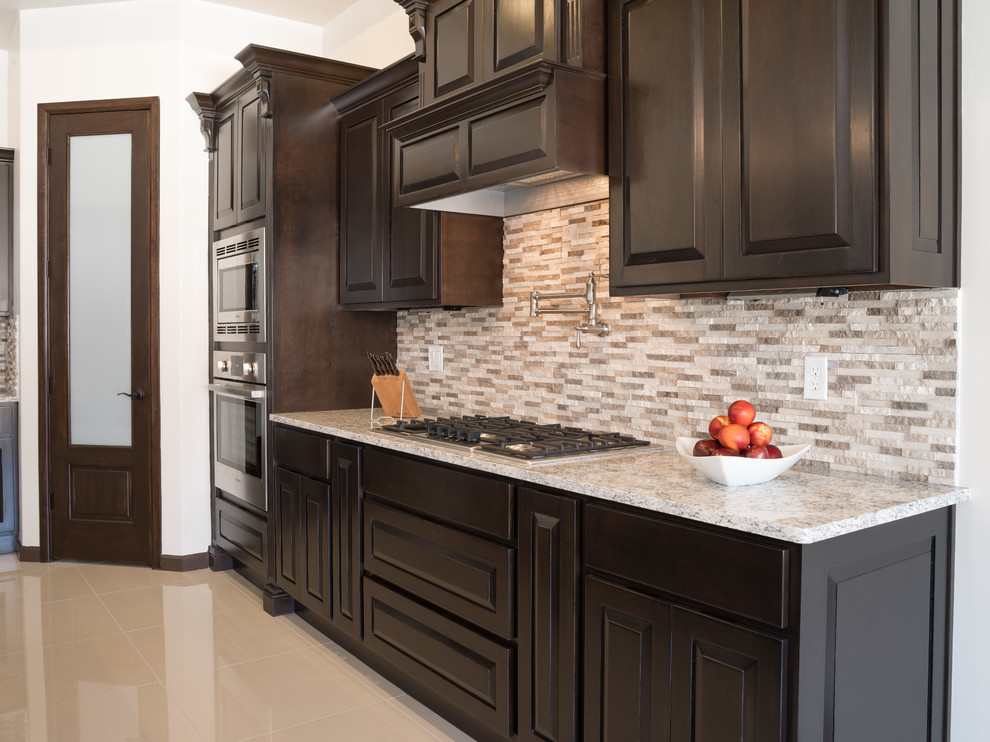 Inspiration for a medium sized classic galley kitchen/diner in Austin with a belfast sink, raised-panel cabinets, dark wood cabinets, granite worktops, brown splashback, stone tiled splashback, marble flooring and no island.