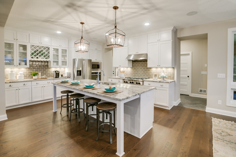 Exempel på ett mellanstort modernt kök, med en dubbel diskho, luckor med profilerade fronter, vita skåp, granitbänkskiva, grått stänkskydd, stänkskydd i keramik, rostfria vitvaror, mellanmörkt trägolv och en köksö