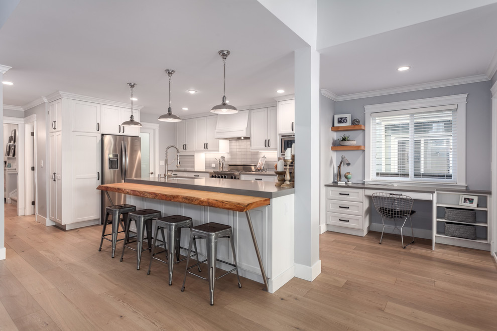 Example of a mid-sized cottage l-shaped light wood floor open concept kitchen design in Vancouver with an undermount sink, recessed-panel cabinets, distressed cabinets, quartzite countertops, gray backsplash, subway tile backsplash, stainless steel appliances and an island