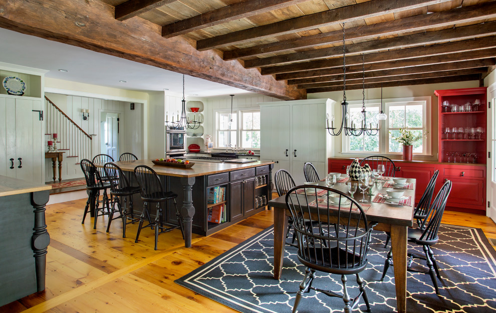 Mid-sized cottage u-shaped light wood floor eat-in kitchen photo in Boston with a farmhouse sink, white cabinets, white appliances, an island, beaded inset cabinets, white backsplash, stone slab backsplash and wood countertops