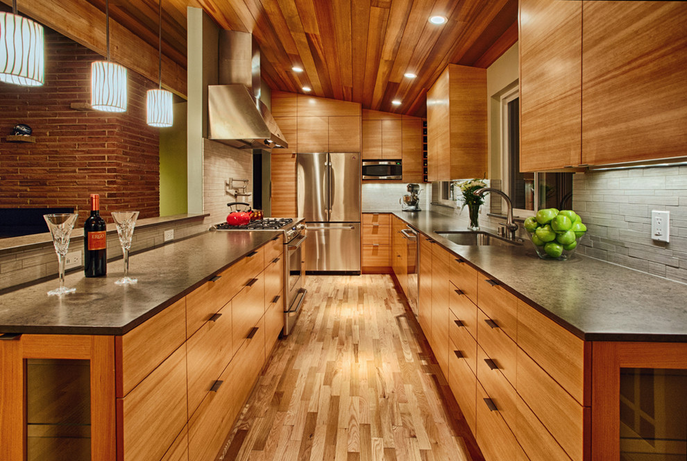 Inspiration for a medium sized contemporary galley open plan kitchen in Seattle with flat-panel cabinets, medium wood cabinets, grey splashback, stainless steel appliances, a submerged sink, engineered stone countertops, porcelain splashback, medium hardwood flooring and brown floors.