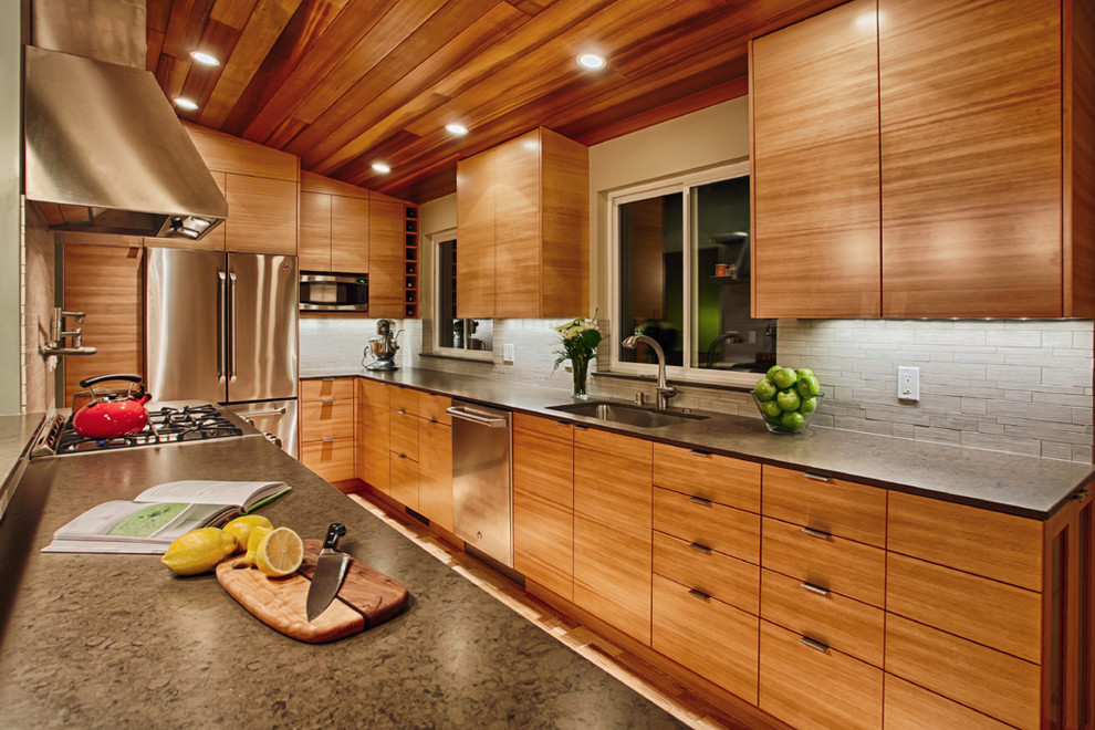 Inspiration for a mid-sized contemporary galley medium tone wood floor open concept kitchen remodel in Seattle with an undermount sink, flat-panel cabinets, medium tone wood cabinets, quartz countertops, gray backsplash, porcelain backsplash and stainless steel appliances