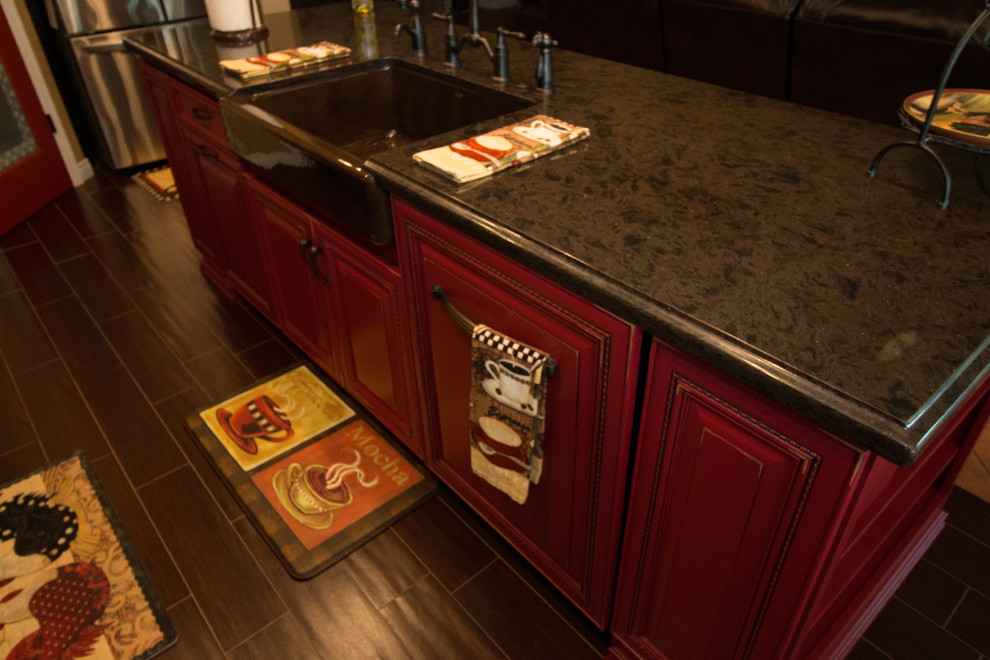 Exempel på ett litet medelhavsstil kök, med en rustik diskho, luckor med upphöjd panel, röda skåp, bänkskiva i kvarts, flerfärgad stänkskydd, stänkskydd i mosaik, rostfria vitvaror, klinkergolv i porslin och en köksö