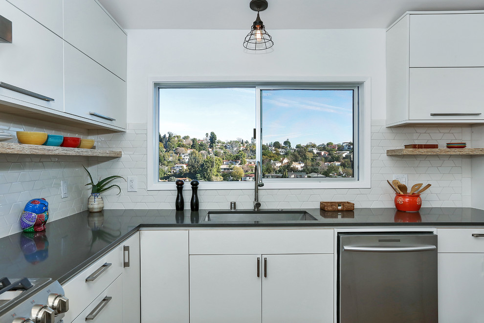 Mittelgroße Moderne Wohnküche in L-Form mit Unterbauwaschbecken, flächenbündigen Schrankfronten, Küchenrückwand in Weiß, Küchengeräten aus Edelstahl und Kücheninsel in Los Angeles