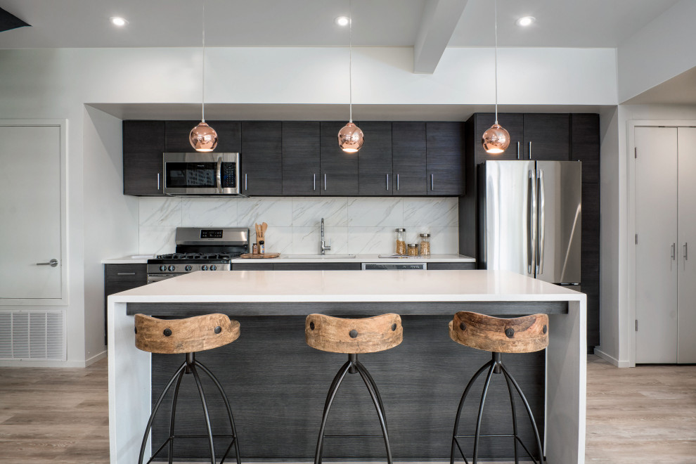 Esempio di una cucina design di medie dimensioni con lavello sottopiano, ante lisce, ante in legno bruno, paraspruzzi bianco, elettrodomestici in acciaio inossidabile, pavimento beige e top bianco