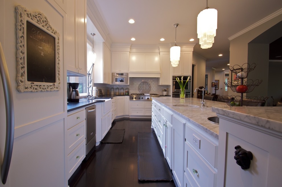 Example of a large classic l-shaped dark wood floor eat-in kitchen design in Portland with an undermount sink, recessed-panel cabinets, white cabinets, stainless steel appliances and an island