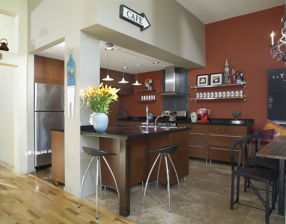 Diseño de cocina comedor contemporánea con armarios con paneles lisos, puertas de armario de madera en tonos medios, salpicadero negro, electrodomésticos de acero inoxidable y barras de cocina