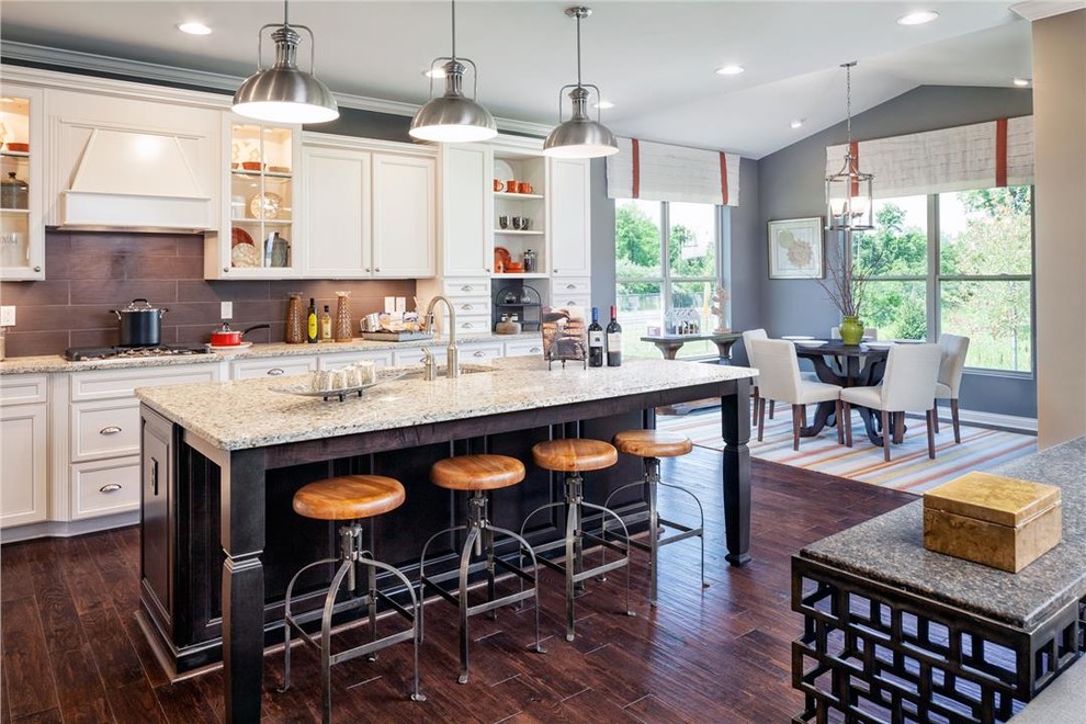 Example of a classic l-shaped dark wood floor eat-in kitchen design in Cincinnati with an undermount sink, recessed-panel cabinets, white cabinets, brown backsplash and an island
