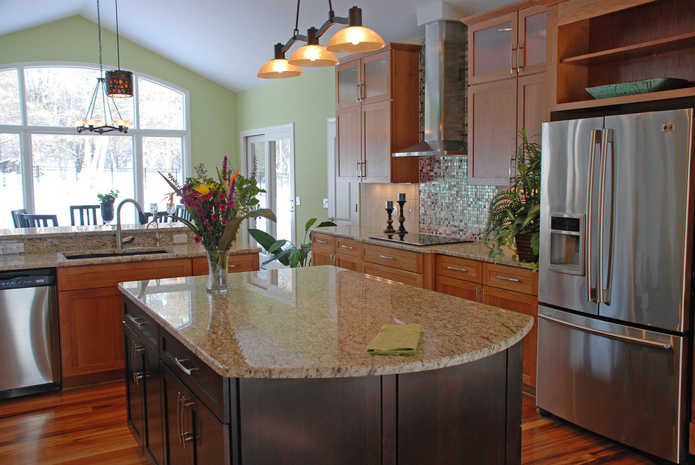 Foto på ett funkis kök, med rostfria vitvaror, granitbänkskiva och stänkskydd i mosaik