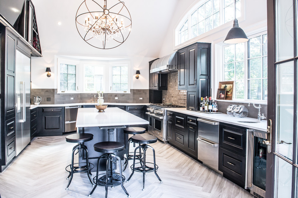 Example of a large transitional u-shaped porcelain tile eat-in kitchen design in New York with raised-panel cabinets, black cabinets, stainless steel appliances, an island, an undermount sink, solid surface countertops, gray backsplash and ceramic backsplash