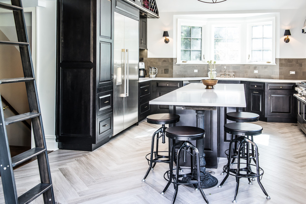 Inspiration for a large transitional u-shaped porcelain tile eat-in kitchen remodel in New York with raised-panel cabinets, black cabinets, stainless steel appliances, an island, an undermount sink, solid surface countertops, gray backsplash and ceramic backsplash