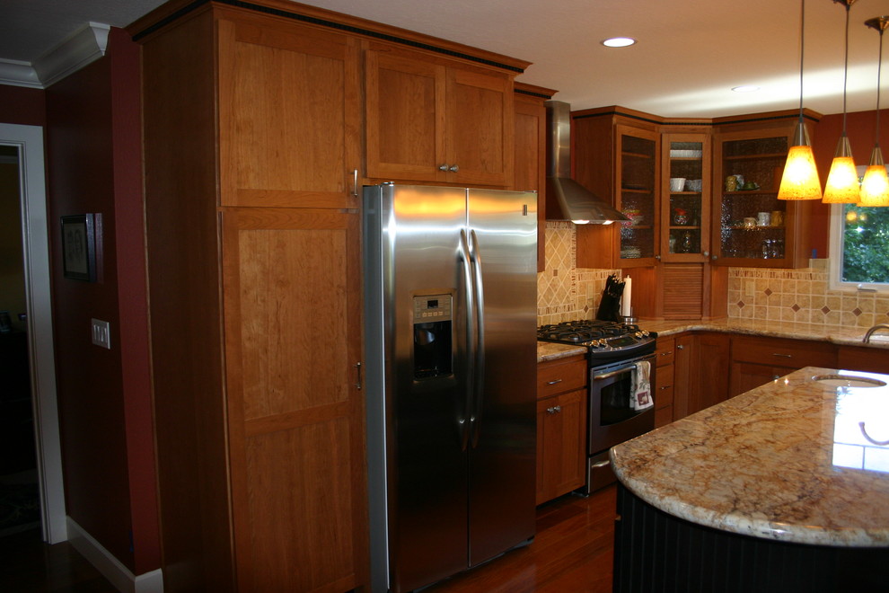 Enclosed kitchen - transitional l-shaped medium tone wood floor enclosed kitchen idea in San Francisco with an undermount sink, shaker cabinets, medium tone wood cabinets, granite countertops, beige backsplash, porcelain backsplash, stainless steel appliances and an island
