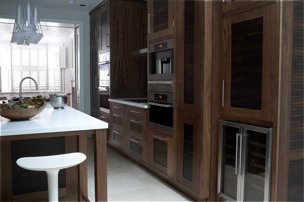 Inspiration for a large contemporary galley kitchen/diner in West Midlands with a submerged sink, recessed-panel cabinets, dark wood cabinets, wood worktops, white splashback, glass sheet splashback, stainless steel appliances, ceramic flooring and an island.