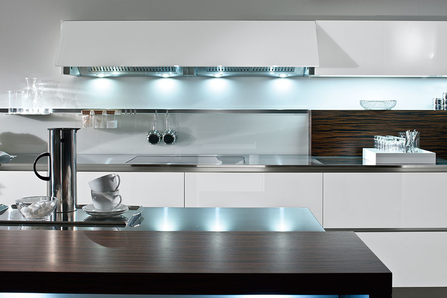 Modern kitchen in London with flat-panel cabinets, white cabinets and an island.