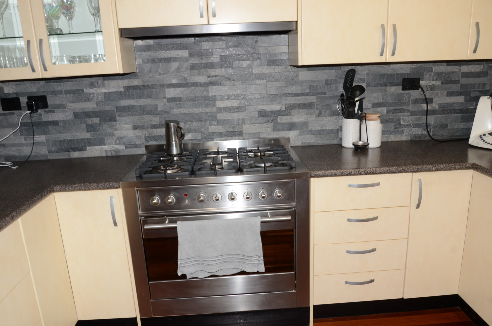 Mittelgroße Moderne Wohnküche in U-Form mit Doppelwaschbecken, gelben Schränken, Quarzwerkstein-Arbeitsplatte, Küchenrückwand in Grau, Rückwand aus Schiefer, Küchengeräten aus Edelstahl, Kücheninsel und grauer Arbeitsplatte in Melbourne