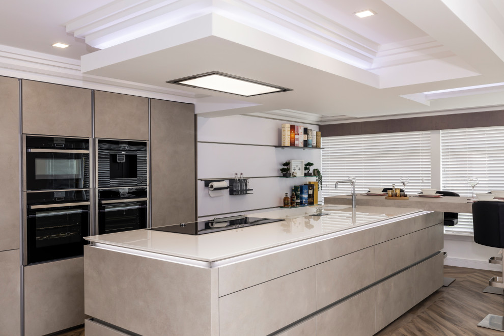 Inspiration for a large contemporary l-shaped open plan kitchen in Other with flat-panel cabinets, engineered stone countertops, black appliances, an island, white worktops, a submerged sink, grey cabinets and brown floors.