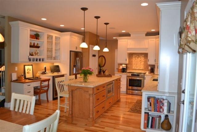 Large elegant l-shaped light wood floor eat-in kitchen photo in Boston with an undermount sink, recessed-panel cabinets, white cabinets, granite countertops, beige backsplash, ceramic backsplash and stainless steel appliances