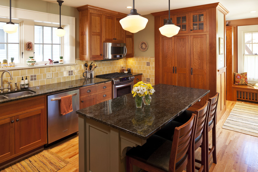 Example of a trendy kitchen design in Minneapolis with glass-front cabinets and stainless steel appliances