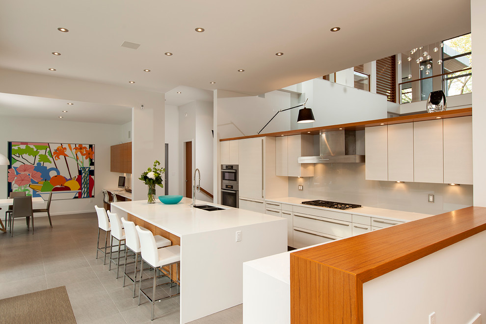 Design ideas for a contemporary open plan kitchen in Edmonton with beige cabinets, beige splashback and glass sheet splashback.