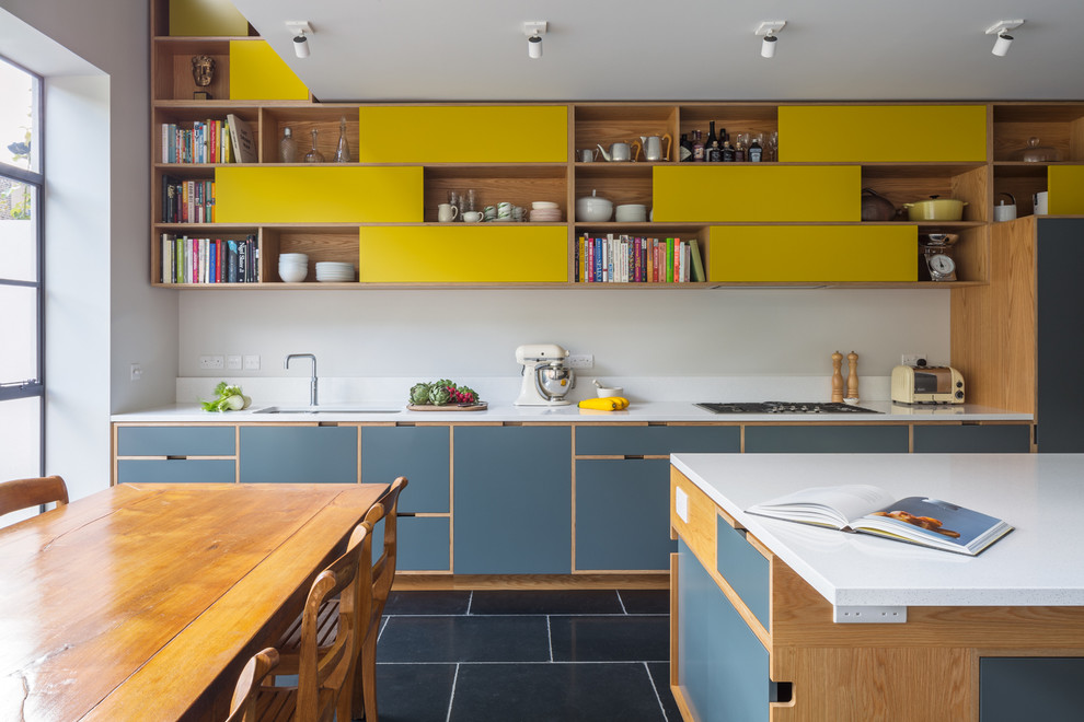 This is an example of a contemporary kitchen in London with a submerged sink, flat-panel cabinets, blue cabinets and white splashback.