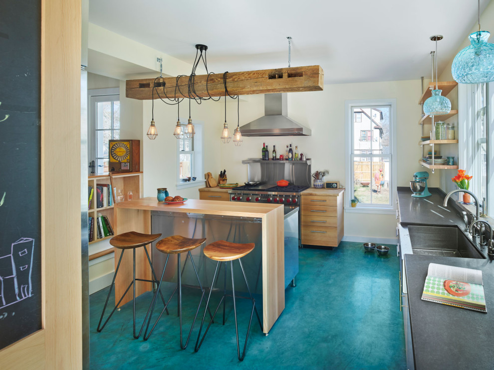 Inredning av ett eklektiskt mellanstort kök, med en rustik diskho, släta luckor, skåp i ljust trä, bänkskiva i rostfritt stål, rostfria vitvaror, betonggolv, en köksö och turkost golv