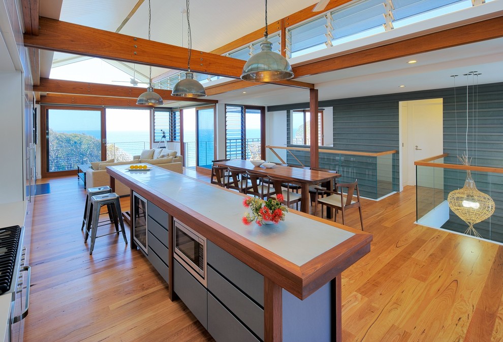 Foto de cocina comedor contemporánea con encimera de zinc, suelo de madera en tonos medios y una isla