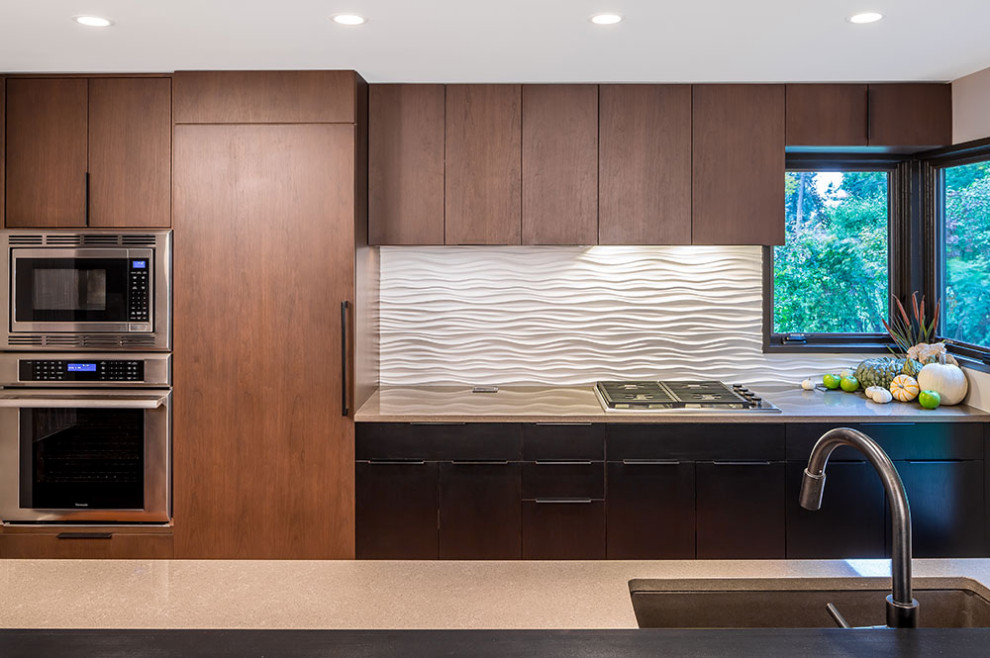 ミネアポリスにあるミッドセンチュリースタイルのおしゃれなII型キッチン (フラットパネル扉のキャビネット、茶色いキャビネット、白いキッチンパネル、シルバーの調理設備、ベージュのキッチンカウンター) の写真