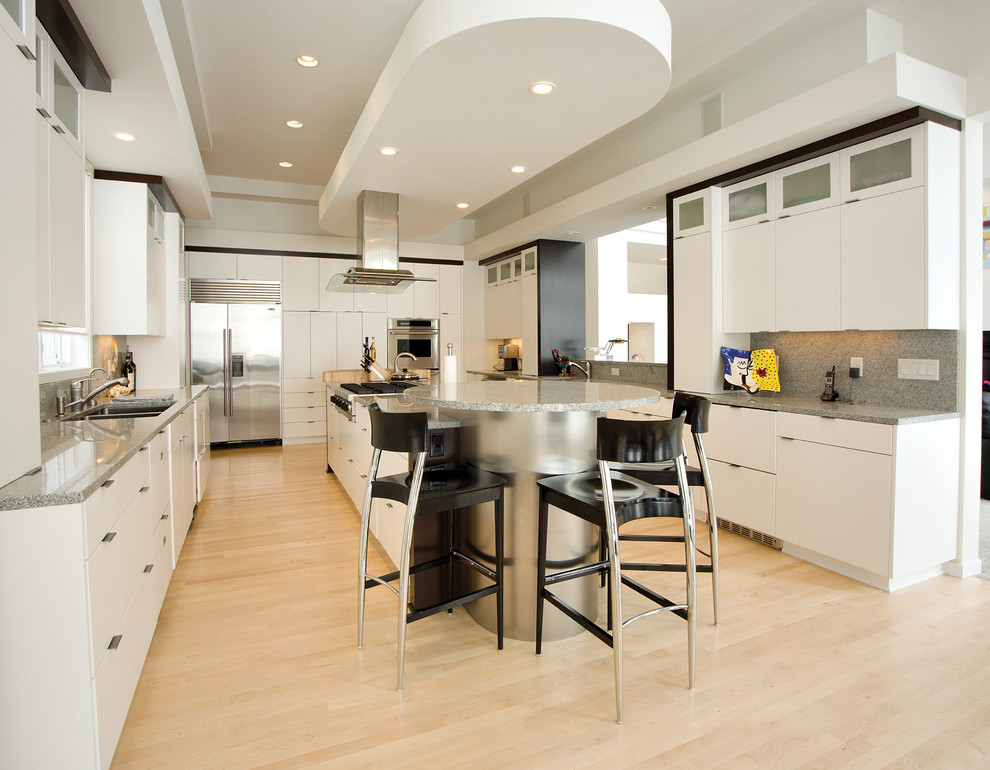 Cette image montre une cuisine design avec un évier encastré, un placard à porte plane, une crédence grise et un électroménager en acier inoxydable.