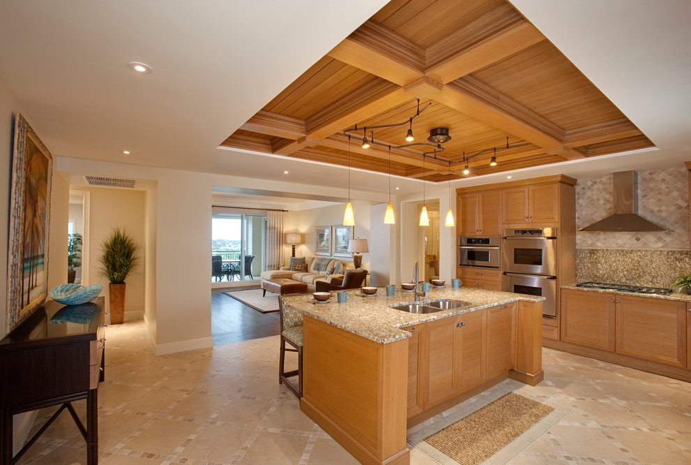 Example of a large island style kitchen design in Miami with an undermount sink, louvered cabinets, light wood cabinets, granite countertops, brown backsplash, stainless steel appliances and an island