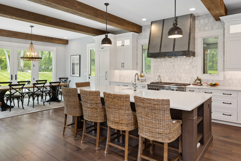 Inspiration for a large farmhouse kitchen in Cincinnati with a belfast sink, shaker cabinets, white cabinets, marble splashback, stainless steel appliances, medium hardwood flooring, an island, white worktops and exposed beams.