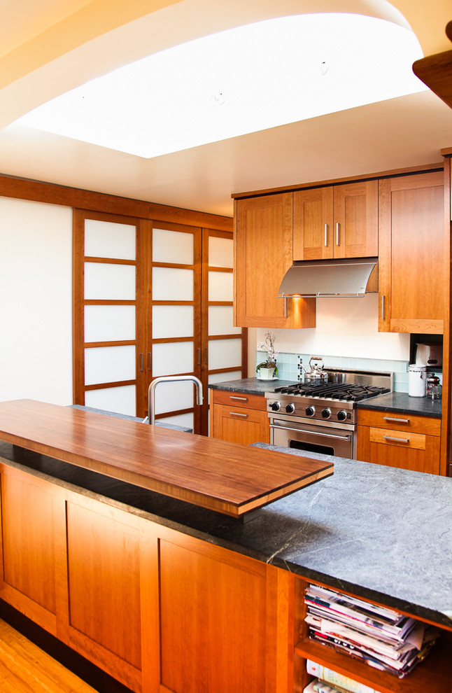 サンフランシスコにあるアジアンスタイルのおしゃれなII型キッチン (シェーカースタイル扉のキャビネット、中間色木目調キャビネット、緑のキッチンパネル、シルバーの調理設備) の写真