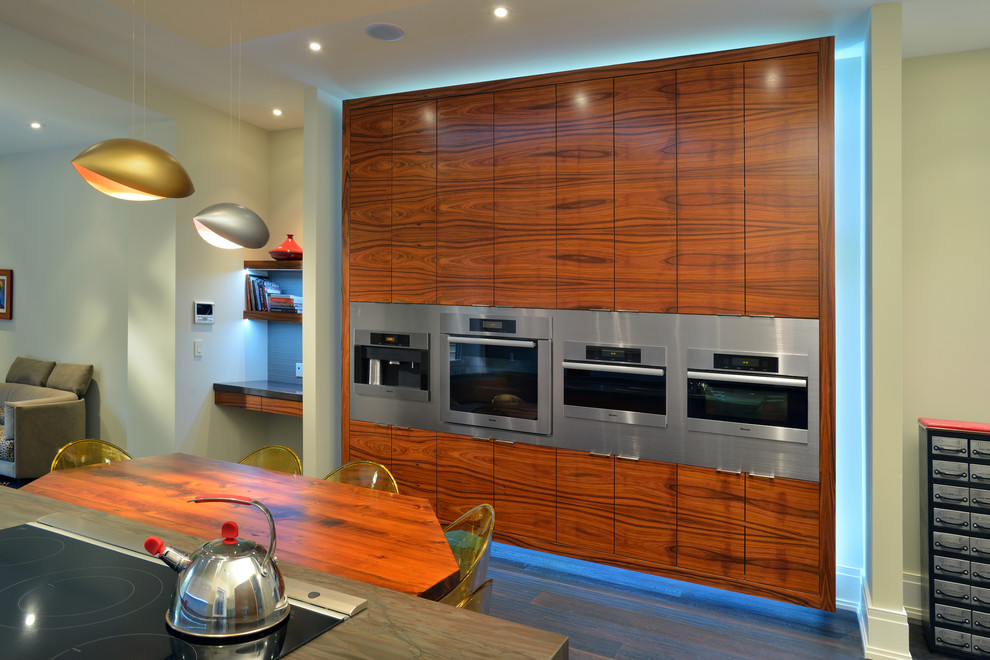 Enclosed kitchen - mid-sized contemporary galley dark wood floor enclosed kitchen idea in Toronto with stainless steel appliances, flat-panel cabinets, medium tone wood cabinets, onyx countertops, blue backsplash, glass tile backsplash and an island
